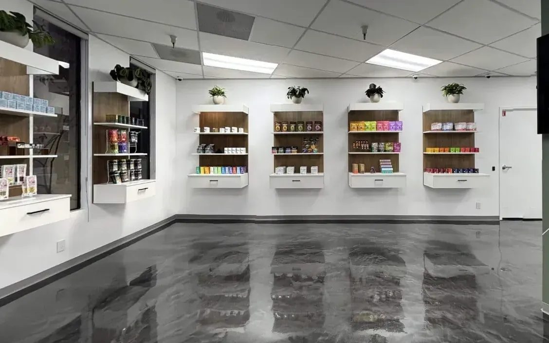 Bright dispensary interior with white shelves and polished concrete floor