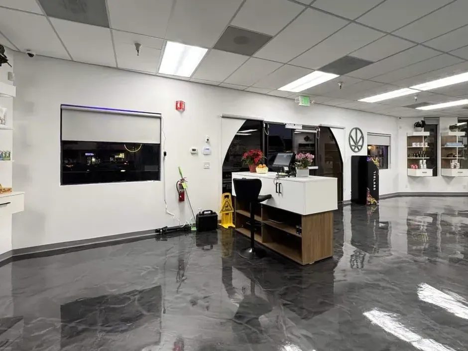 Cannabis dispensary checkout counter with glossy floor and display shelves